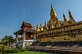 Vientiane, Laos - Surrounded by a cluster of pointed minor stupas the huge Pha That Luang shined under the warm light of the sunset.  